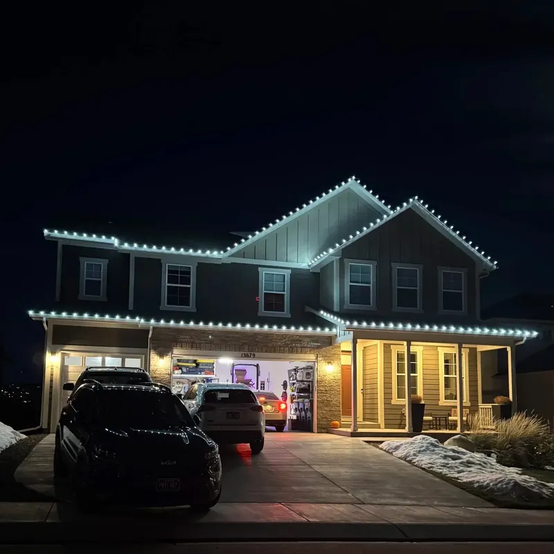 Two-story home outlined in cool white lights